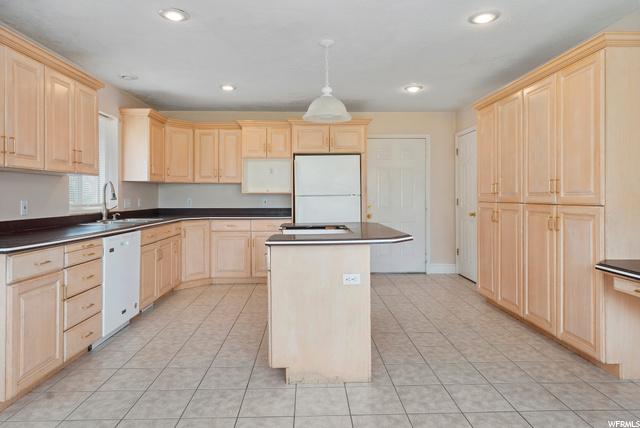 Large kitchen with island for cooking.  Pantry door on the back right next to door leading to garage.