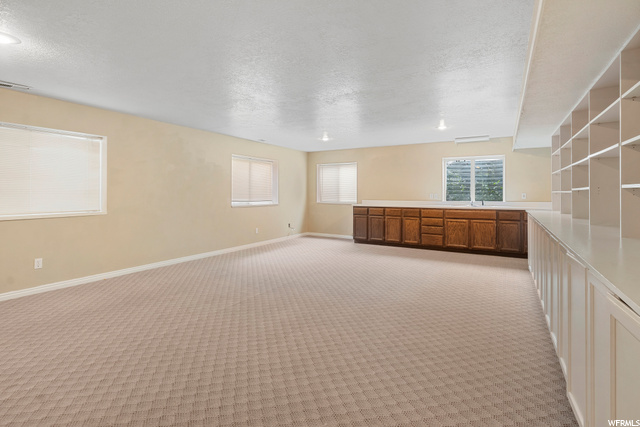 Huge family room with built-ins across one wall and kitchen cabinets with double sink for entertaining!