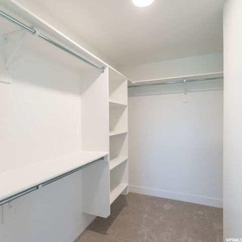 Walk in closet featuring light carpet