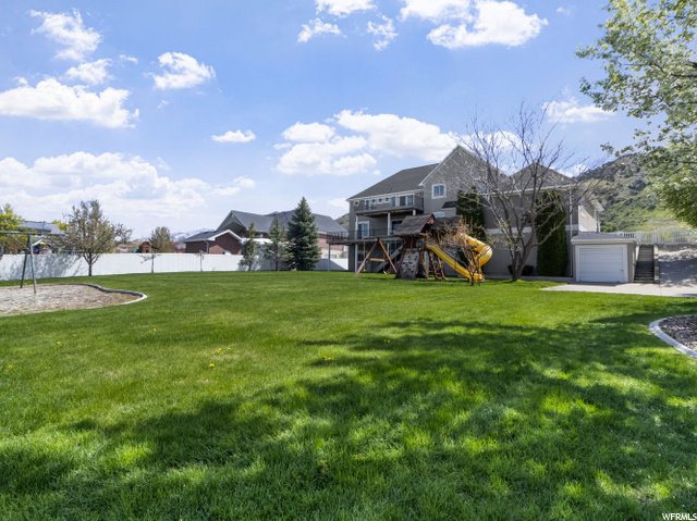 Yard has a play gym, swing set and drinking founta