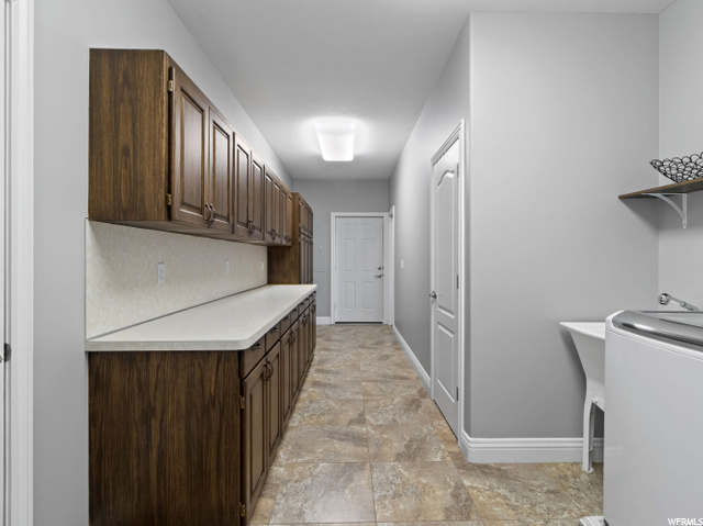 Main floor laundry with utility sink and storage