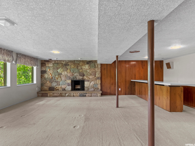 large open room w fireplace down and wet bar