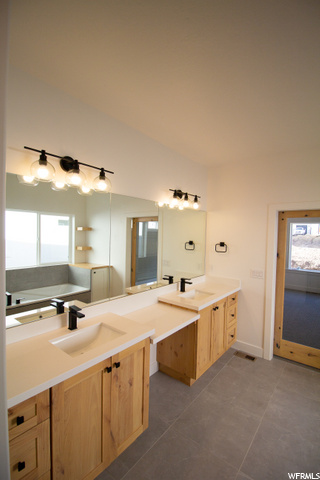 bathroom featuring a wealth of natural light, tile floors, mirror, and dual vanity