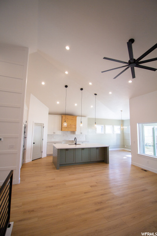 kitchen featuring vaulted ceiling, natural light, a ceiling fan, light hardwood flooring, and pendant lighting