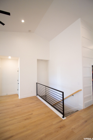 staircase with wood-type flooring and a ceiling fan
