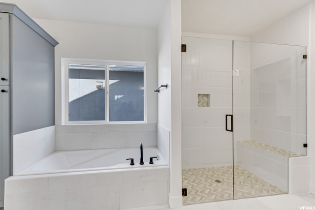bathroom featuring tile floors and independent shower and bath