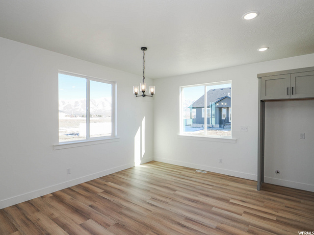 wood floored empty room with natural light