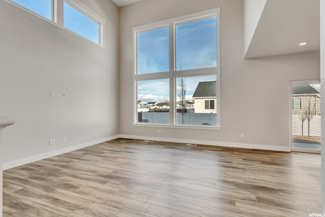 hardwood floored spare room featuring natural light
