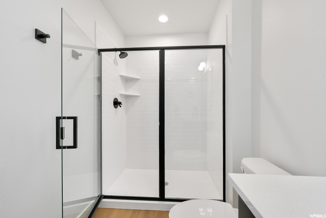 full bathroom featuring toilet, vanity, and shower booth