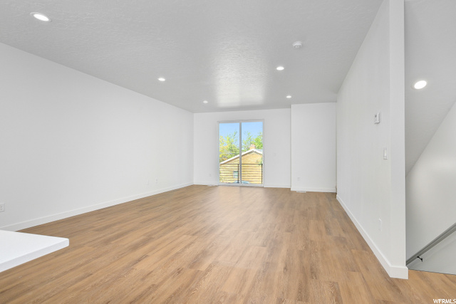 wood floored empty room with natural light