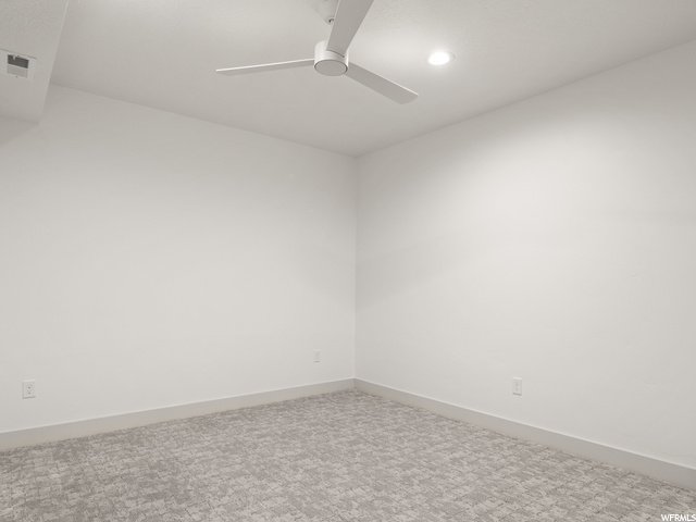 empty room with carpet and a ceiling fan