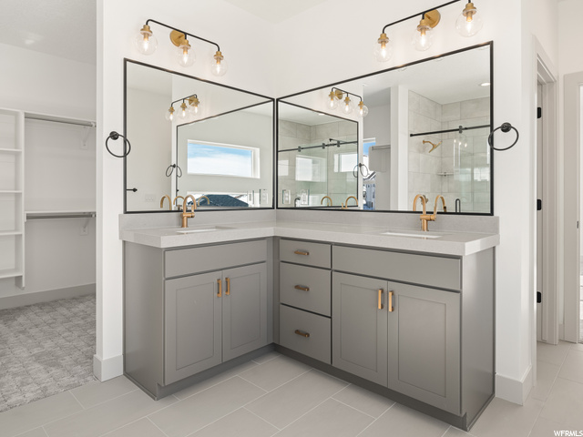 bathroom featuring tile flooring, multiple mirrors, and double large sink vanity