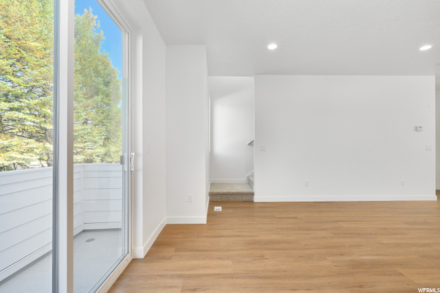 empty room featuring a healthy amount of sunlight and hardwood flooring