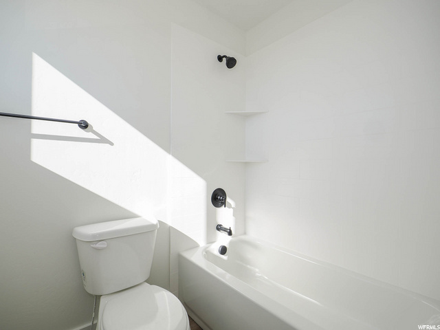 bathroom with shower / bathing tub combination and toilet
