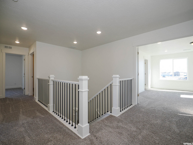 corridor with natural light and carpet