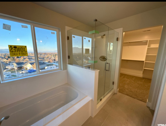 bathroom featuring natural light, tile flooring, and shower with separate bathtub