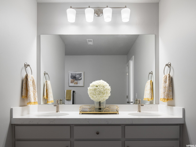 bathroom with multiple mirrors and dual vanities