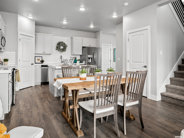 dining space featuring hardwood flooring and stainless steel finishes