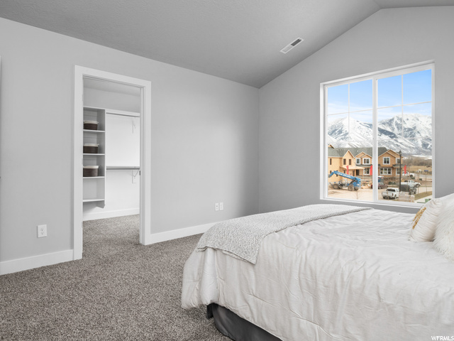 bedroom featuring carpet and lofted ceiling