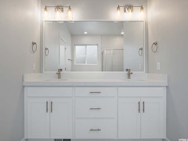 bathroom featuring double large vanity and mirror