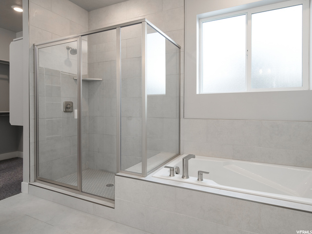 bathroom with natural light and separate shower and tub enclosures