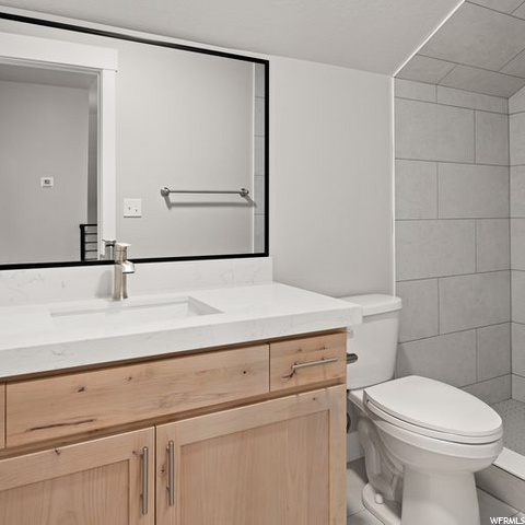 half bath featuring toilet, vanity, and mirror