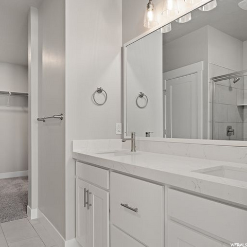 bathroom with shower cabin, dual large bowl vanity, and mirror