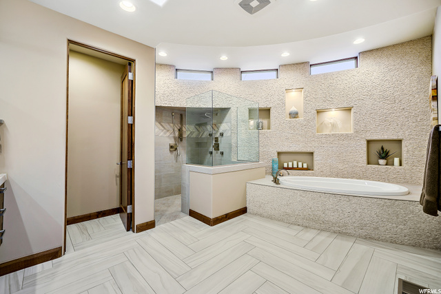 Owner's bath with curved stone tile