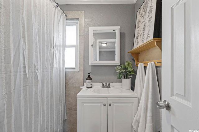 bathroom with shower curtain, vanity, and mirror