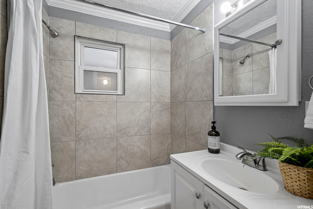bathroom with bath / shower combination, shower curtain, vanity, and mirror
