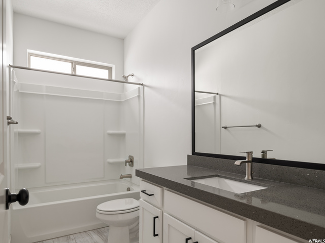 full bathroom with toilet, shower / tub combination, mirror, and large vanity