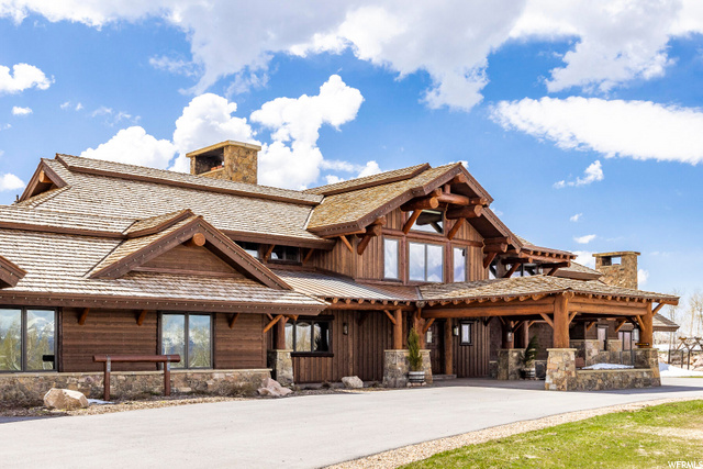 1975 N WESTWARD HO RD Heber City, Utah Create a lasting legacy at this awe-inspiring mountaintop equestrian ranch located on 168 acres in Wolf Creek Ranch, a quick 20 minutes from Heber City, private airport, and Deer Valley Resort. Discover a new frontier while entering through the tree-lined driveway and heated port-a cochere to the entirely private Roll Tide Estate completed in 2020. The breathtaking foyer with 36-foot vaulted ceilings adorned with log beams will start you on your journey to being captivated by the panoramic window-framed vistas of Mount Timpanogos enjoyed throughout the mountain-top 8-bedroom, 11-bathroom ranch. The picturesque great room is anchored by a soaring natural rock surrounding the wood-burning hearth, large windows framing the fully landscaped yard, and the Wasatch Back mountain range in the foreground and sunsets in the background. The main level offers a saloon-style bar providing a rich and nostalgic ambiance reminiscent of a bygone era of rugged charm and old-fashioned hospitality and is only steps away from the home theater. The main level master features a wood-burning fireplace and vaulted beamed ceiling creating the ultimate owner's retreat. Entertain in the gourmet kitchen centered by a large island topped with leathered granite. Wolf appliances, two Subzero refrigerators, a Miele coffee station, and a butler's pantry are perfectly situated to host in the dining room or outdoor patio with heaters and a wood-burning fireplace. A yoga space with a steam room and dry sauna is complemented by an exterior yoga deck. Exercise, work, and relax on the newly finished lower level with a home gym, two family rooms, and a dedicated climate-controlled wine room. The ventilated cigar lounge is one of two safe rooms. Climb the wide wood staircase or install an elevator to ride up to the upper-level game room, 3 bedrooms, and bunk room. Laundry areas on each level. A Savant home system, radiant heat, air conditioning make this a convenient mountain-top estate. Explore the 4 miles of trails on the equestrian property or venture further on the Wolf Creek Ranch summer and winter-maintained trail system, 3 community yurts, 2 catch-and-release fishing ponds, sledding hill, and one mile of private water on the Upper Provo River.