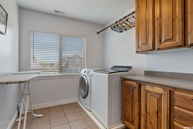 Clothes washing area featuring tile flooring and washer / dryer