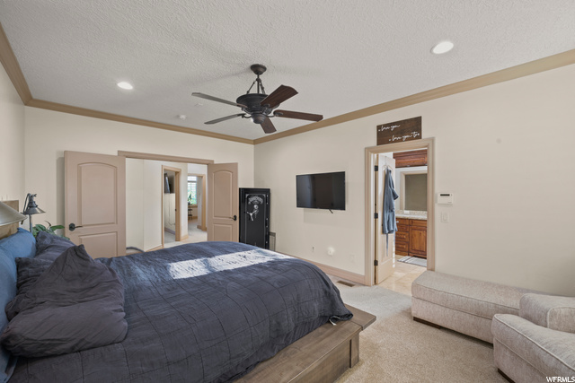 Primary Bedroom Carpeted with a ceiling fan and TV
