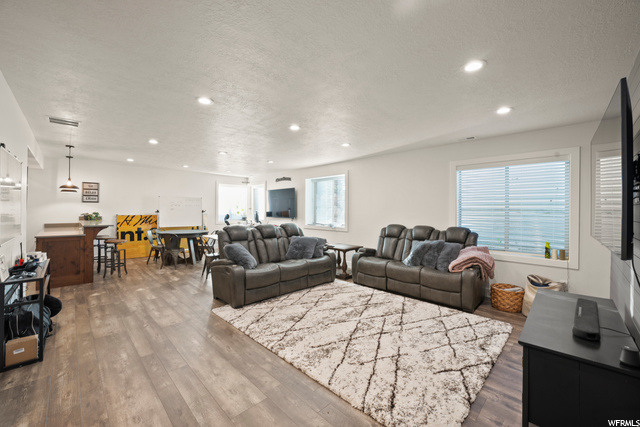 Living room featuring a breakfast bar area, plenty of natural light, and LVP flooring