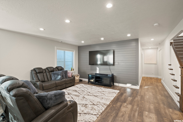 Living room with wood-type flooring, a fireplace, and TV