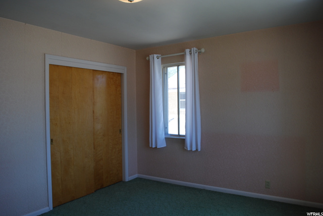 Carpeted bedroom featuring multiple windows