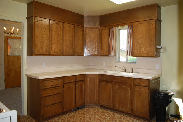 Kitchen featuring natural light, brown cabinets, light countertops, and light flooring