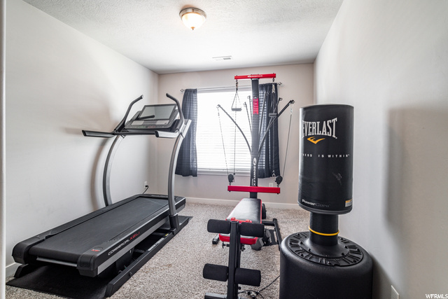 This is a bedroom being used as an exercise area with natural light.