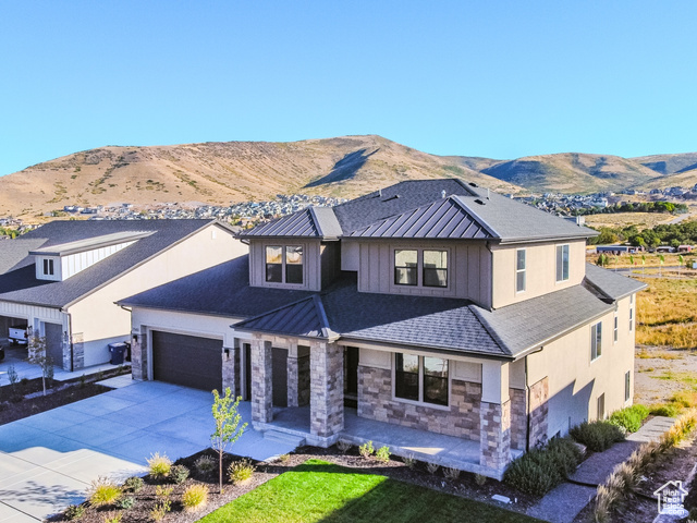 View of front facade featuring a mountain view, a garage, and a front lawn