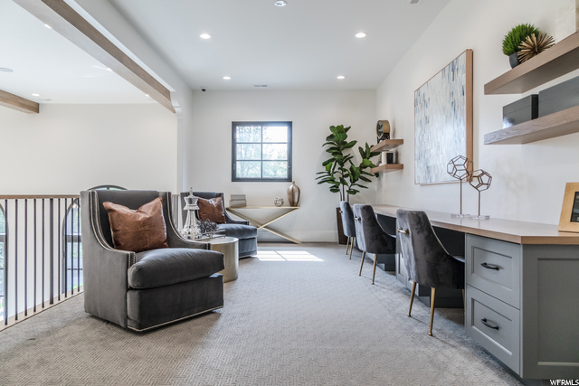 Interior space with beamed ceiling and light carpet