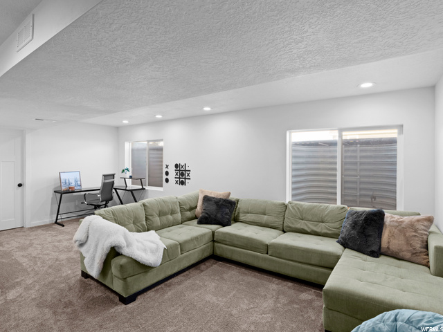 Living room featuring carpet floors and a textured ceiling