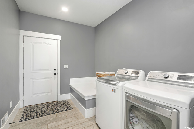 Laundry room featuring separate washer and dryer and light hardwood flooring