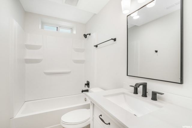 Full bathroom featuring vanity with extensive cabinet space, shower / tub combination, and mirror