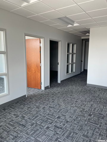 Carpeted spare room featuring a drop ceiling