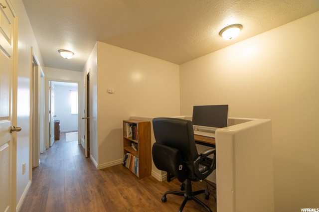 Hardwood floored office with a textured ceiling