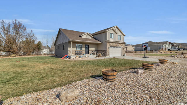 View of front of property featuring a garage and a front yard