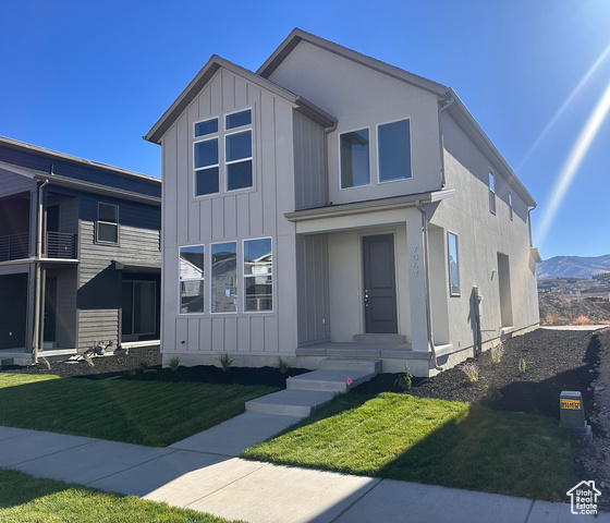 View of front of property featuring a mountain view and a front yard