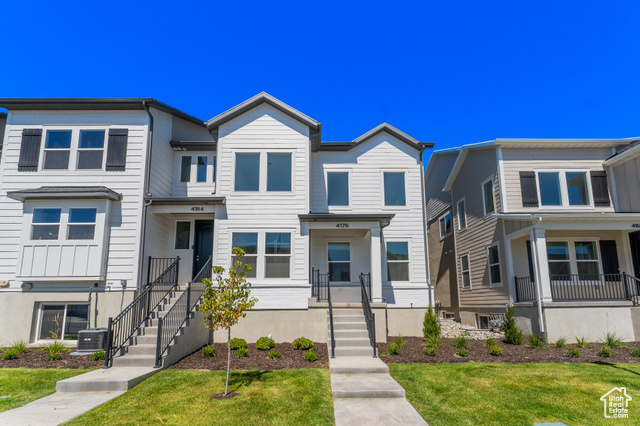 View of property featuring a front yard and central air condition unit