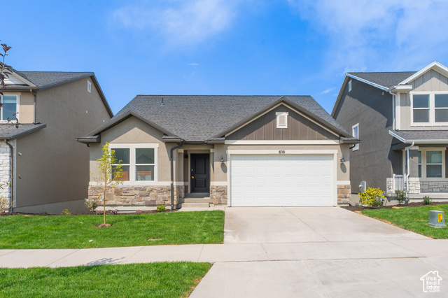 Craftsman-style home with a front yard and a garage